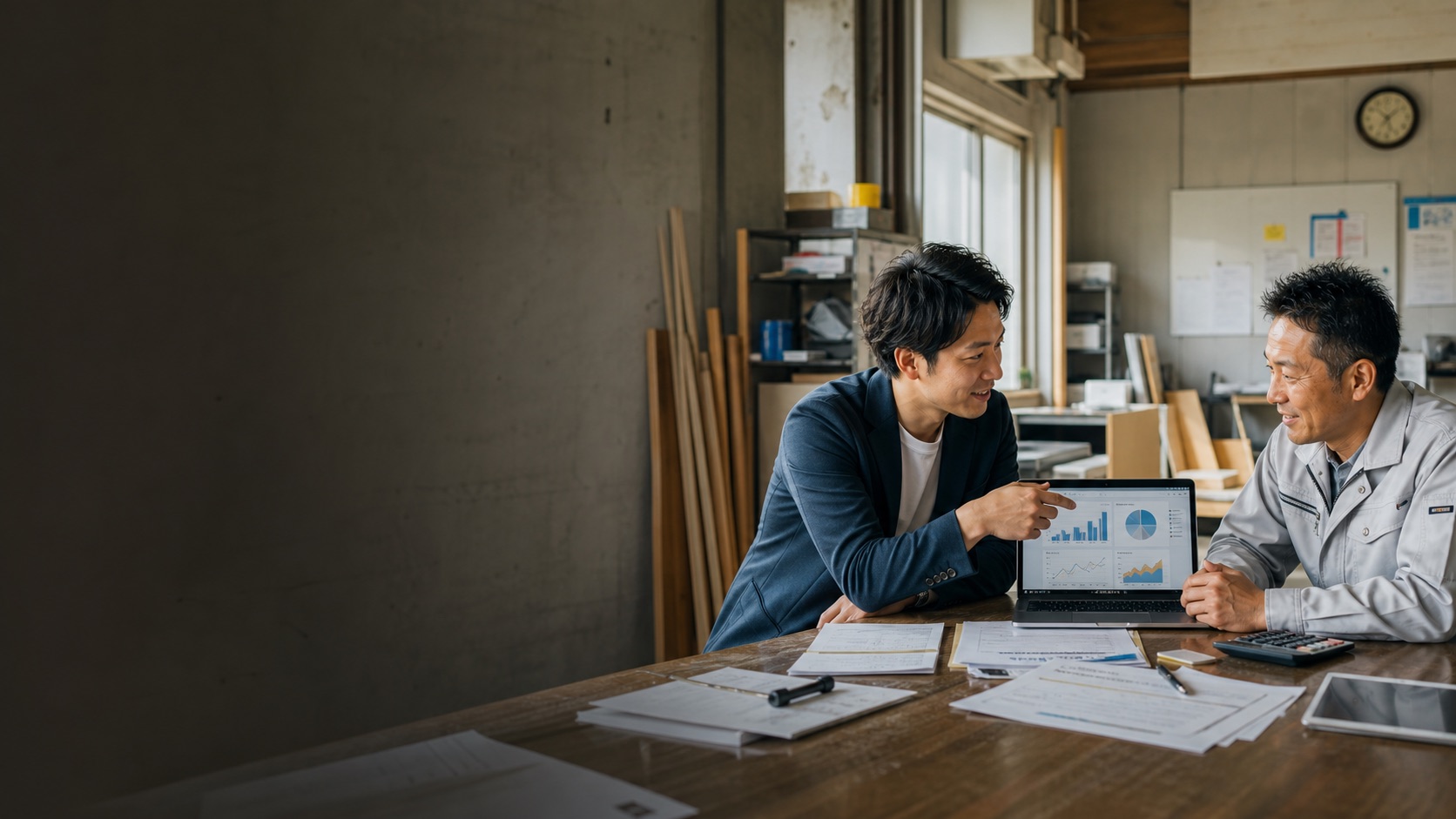 中小企業の現場で、業務データを見ながら相談している様子